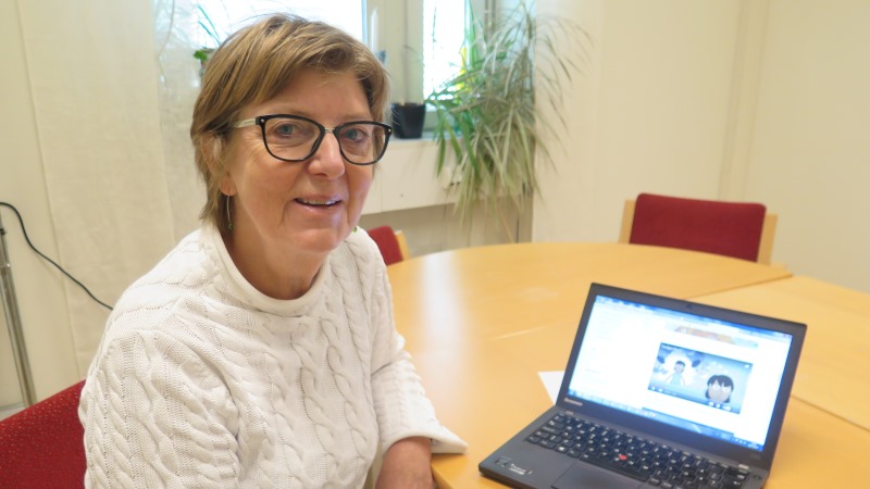 Projektledaren Ann-Marie Stenhammar har kort ljust hår och glasögon och sitter framför en laptop med animerad film på skärmen.