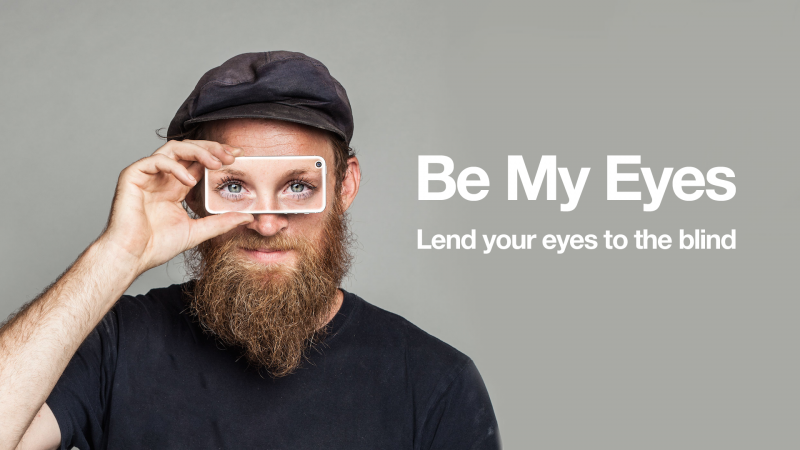 En skäggig man håller en smartphone över sina ögon. Smartphonens skärm har ett par ögon.