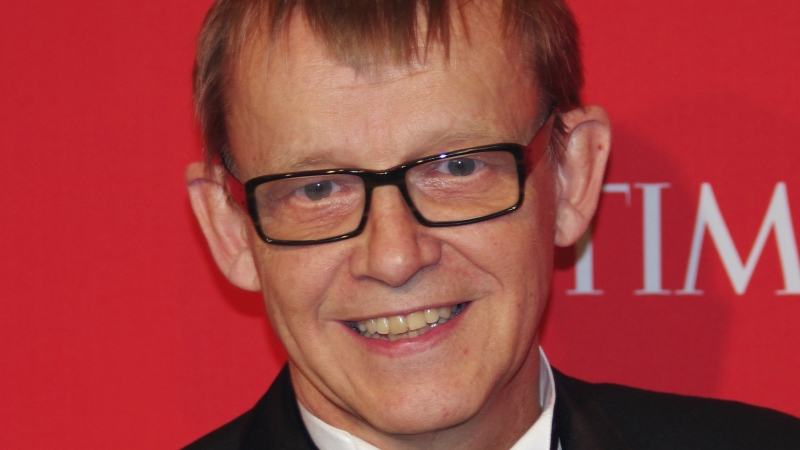 Porträttbild på Hans Rosling. Han har kort hår, fyrkantiga glasögon och ser glad ut.