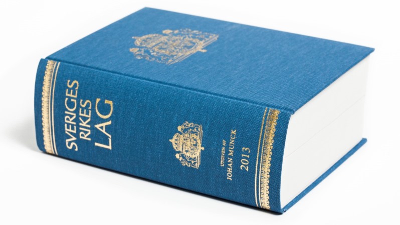 En blå, tjock bok med guldtext i versaler: SVERIGES RIKES LAG.
