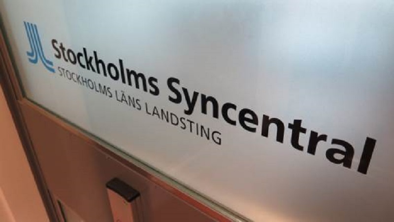 En skylt på en frostad glasskiva med texten Stockholms Syncentral, Stockholms Läns Landsting