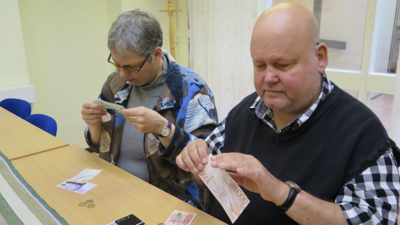 Anita Maddock och Rolf Eriksson testar mynt och sedlar.
