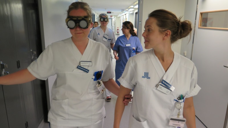 Skjuksköterskor provar stora glasögon som ger illusion av synnedsättning.