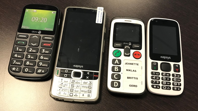 Fyra mobiltelefoner i olika utföranden ligger intill varandra på ett bord.
