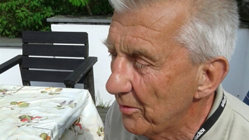 Närbild på en äldre man med halvslutna ögon, vitt hår och ansiktet till hälften bortvänt.