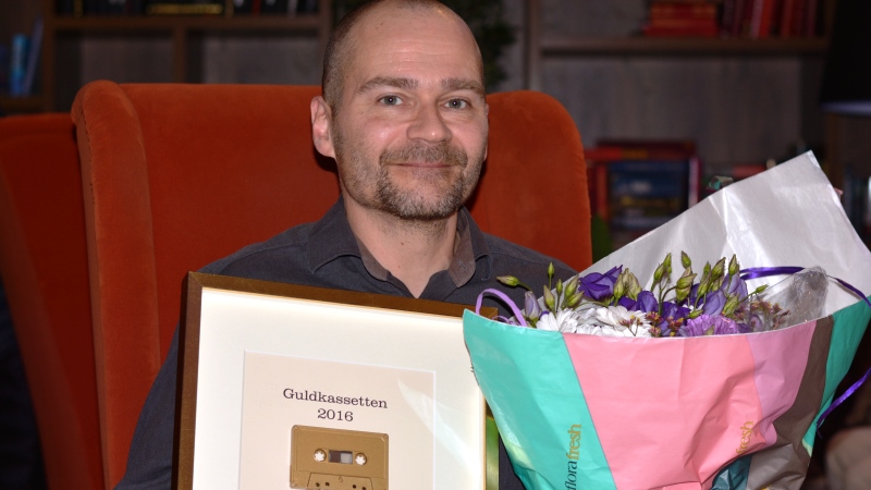 Bild på Mats Sundling med diplom och blommar.