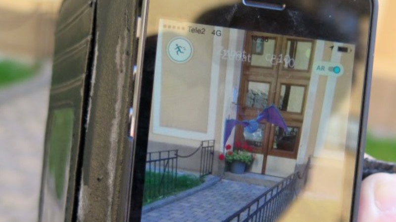 Bild på mobiltelefonskärm där en tcknad blå figur flyger framför en dörr.