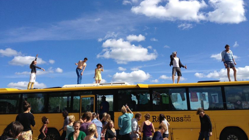 En gul buss med männiksor både utanför och på taket.