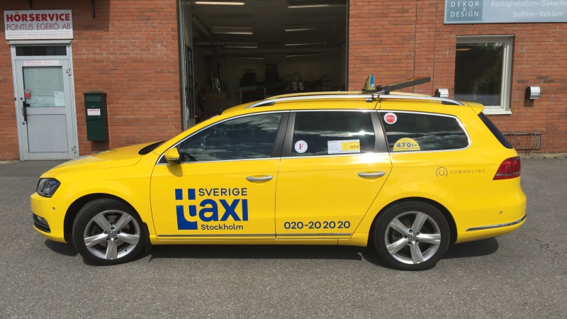Bild på gul bil med texten Sverigetaxi i blått på sidan.