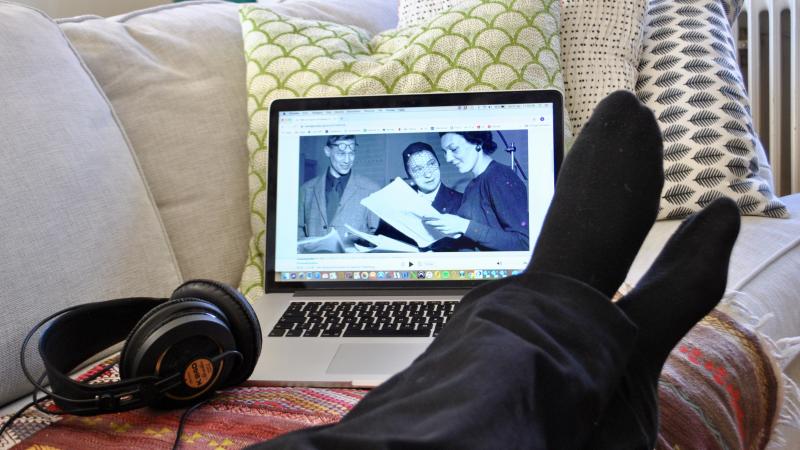 bild på underben, någon ligger i soffa tittar på en laptop med en svartvit film.