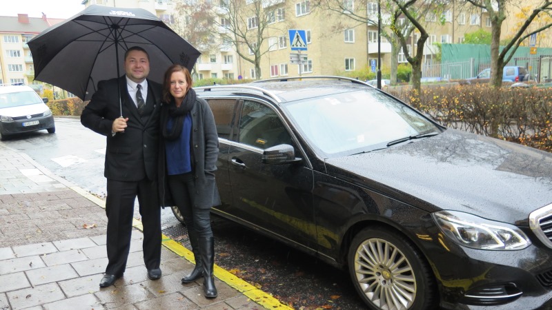Mia Fahlén med chaufför poserar framför taxibilen.