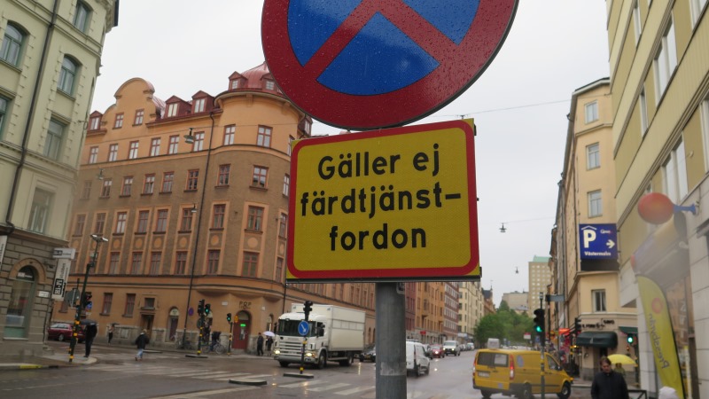 Stoppskylt i gatumiljö med texten "Gäller ej färdtjänstfordon"