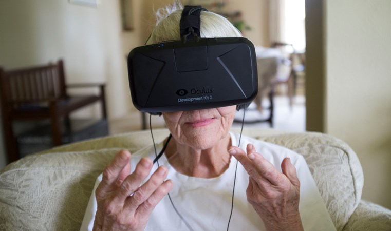 En äldre kvinnas ansikte täcks till stor del av svarta VR-glasögon med fästrem över huvudet